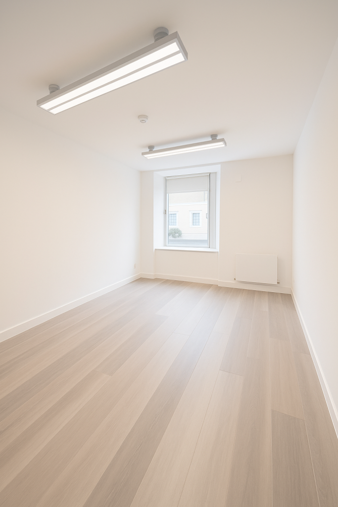 Minimalist clinical room for rent in Knightsbridge with natural light and wood flooring.