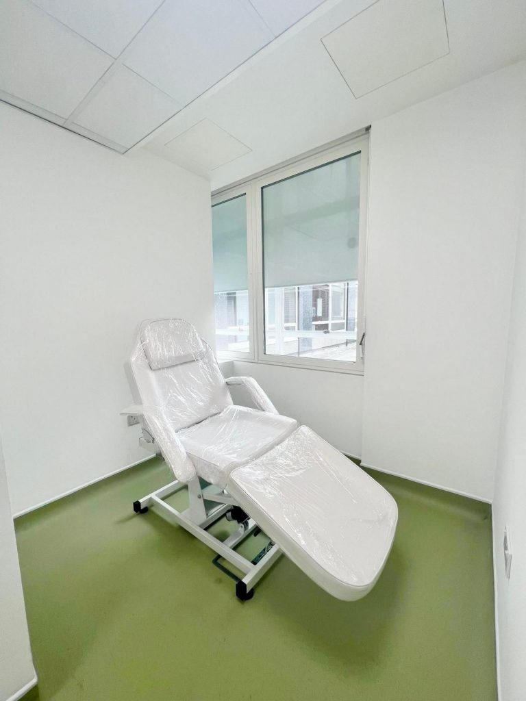 Clinical room at 33 Cavendish Square, Room 244 with treatment bed and bright natural light.