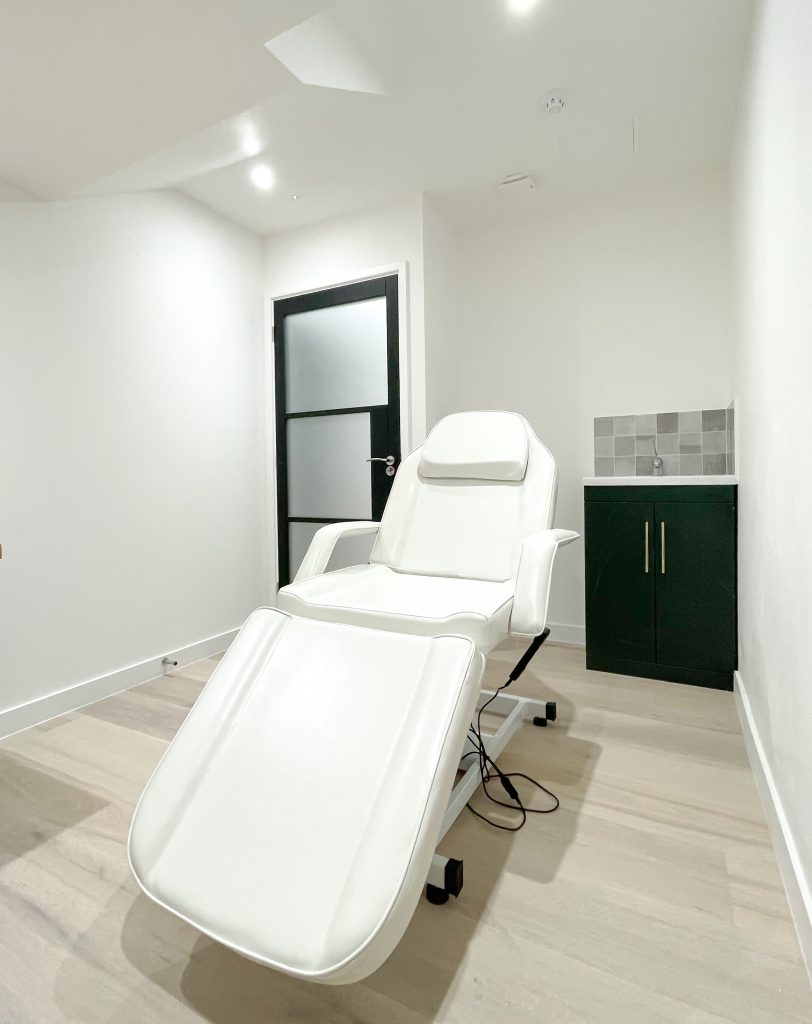 Modern medical room with a reclining treatment chair, sleek cabinetry, and minimalist decor at 27 Hill Street, Mayfair.