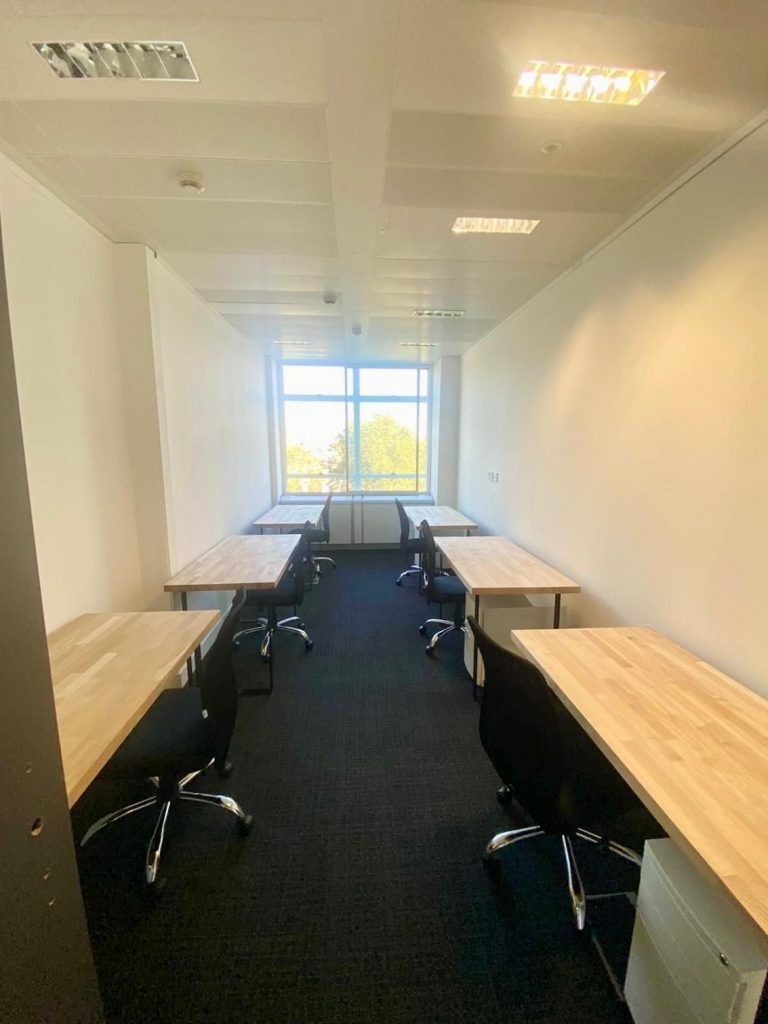 Modern office space at 33 Cavendish Square with six desks, ergonomic chairs, natural light, and a window view.